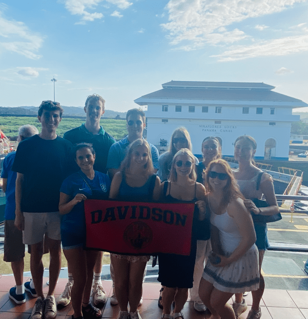 a group of students stand in front of the Panama Canal