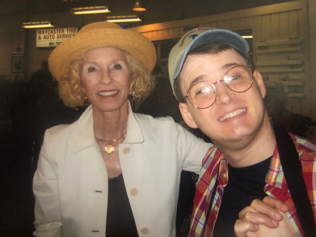an older woman and a younger man smiling together