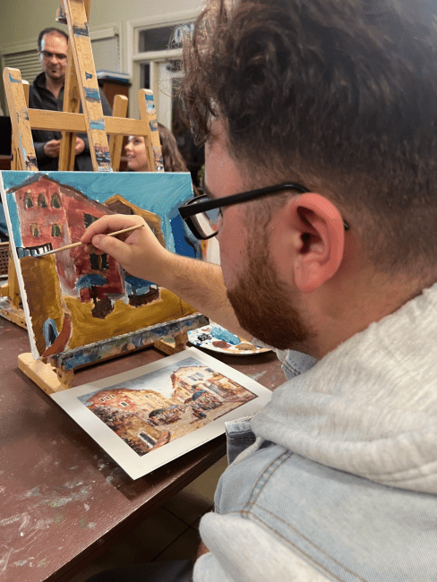 a young man paints on a canvas