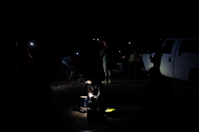 a group of campers eating food at night