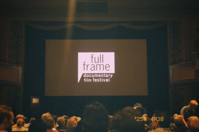 a movie theatre with a screen that reads "full frame documentary film festival"