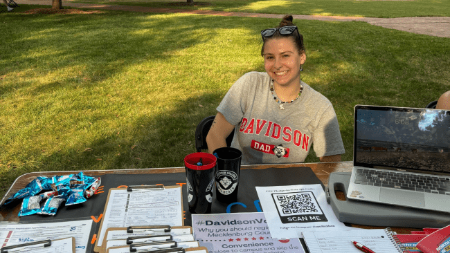 a young woman smiling sitting at a table