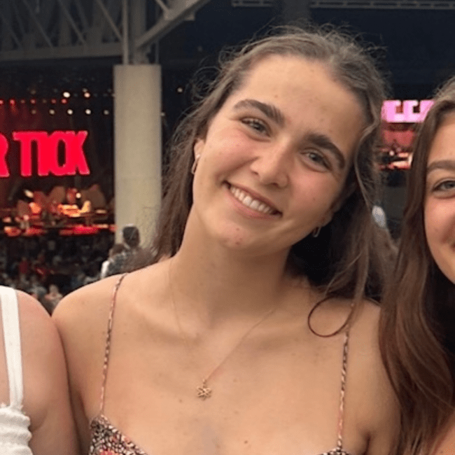 a young woman with curly brown hair at a concert