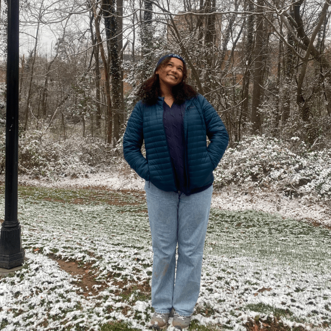 a young woman wearing a jacket and sweats on a snowy day