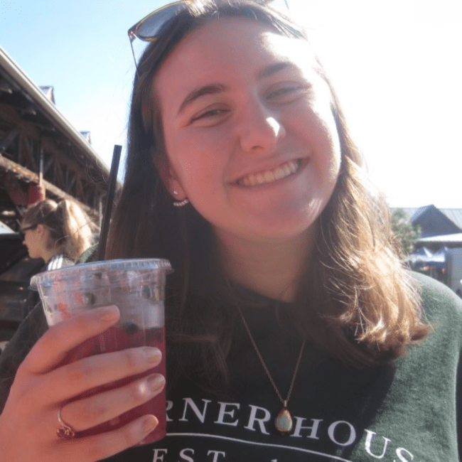 a young woman holding an iced tea and smiling