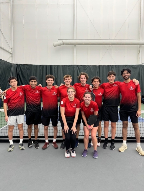 a group of pickleball players on an indoor court wearing red uniforms