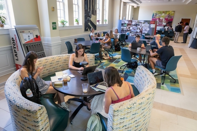 students study in booths and tables in a brightly lit space