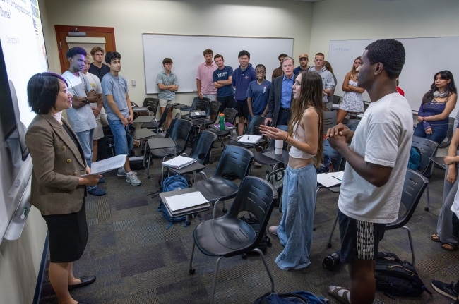 a group of students in a classroom along with a professor and guest speaker