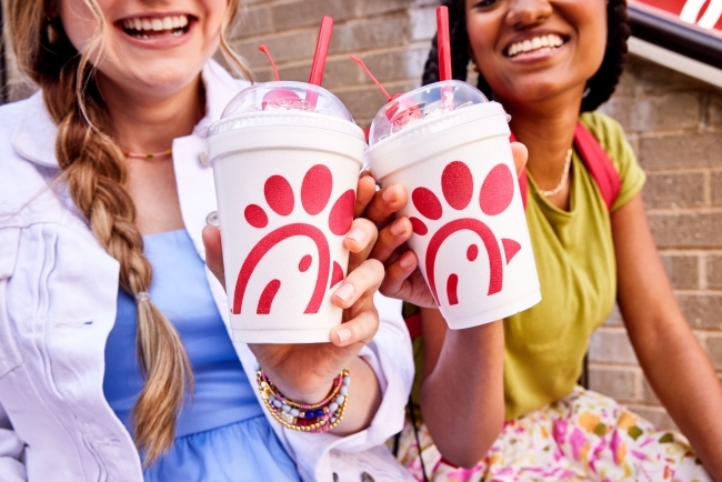 two young women hold up milkshakes from chick-fil-a