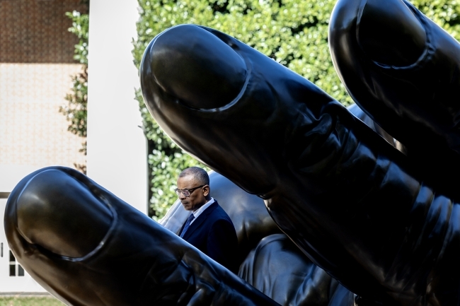 Anthony Foxx is visible between the fingers of the hand sculpture