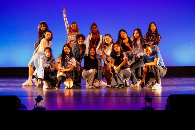 a group of students pose together after a dance performance on stage