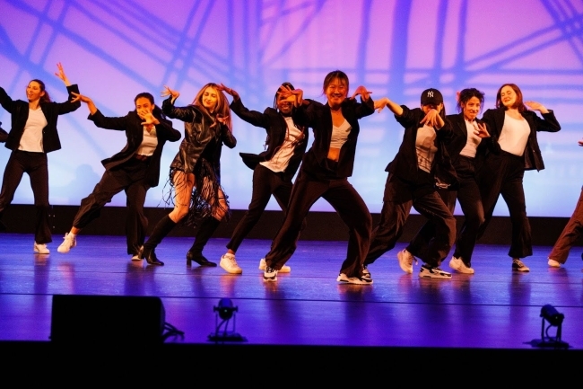 a group of students dance on stage