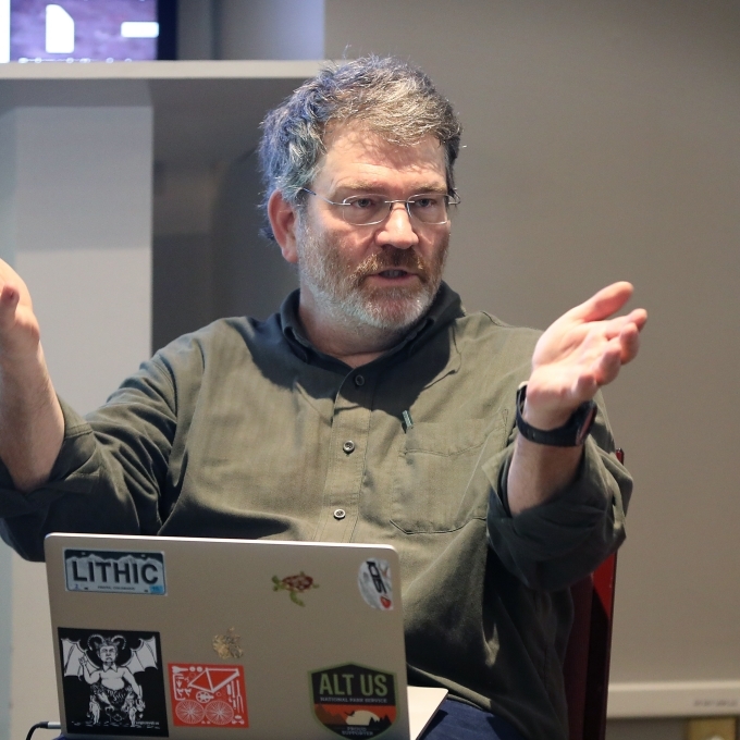 Scott Denham sits in front of laptop and adds to the conversation