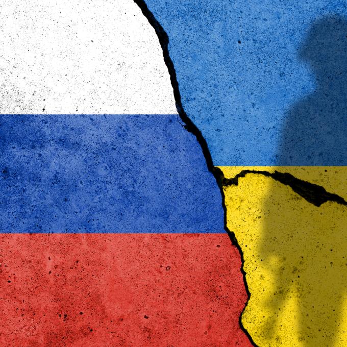 Russian and Ukraine Flags on Cracked pavement