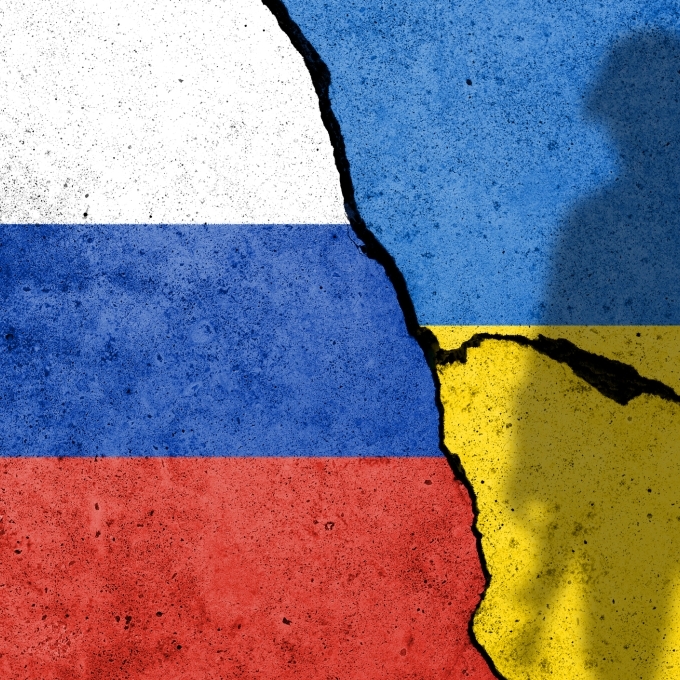 Russian and Ukraine Flags on Cracked pavement