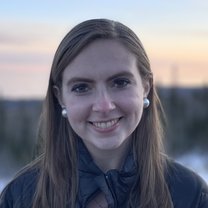 A white woman with brown hair smiling