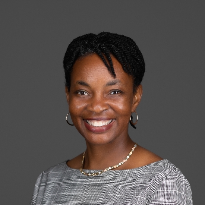 a young Black woman with short hair wearing a grey top