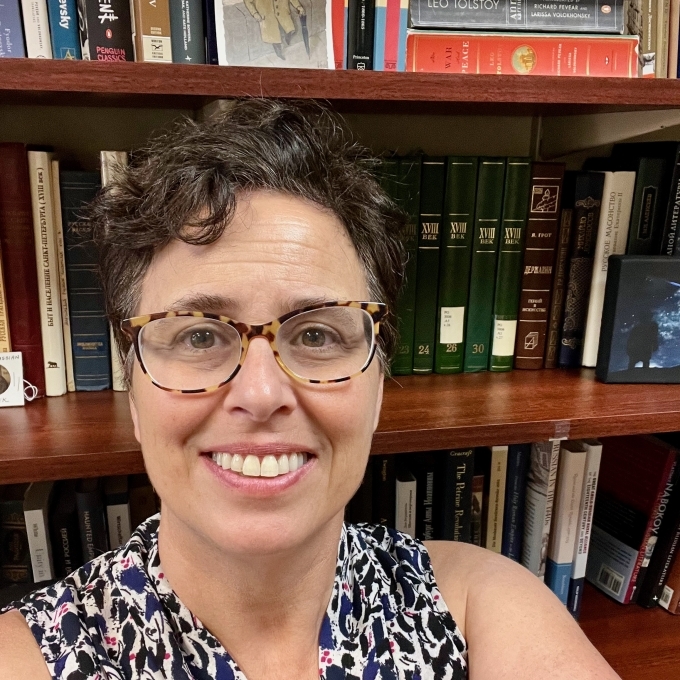 Woman smiling at camera with short black hair and glasses