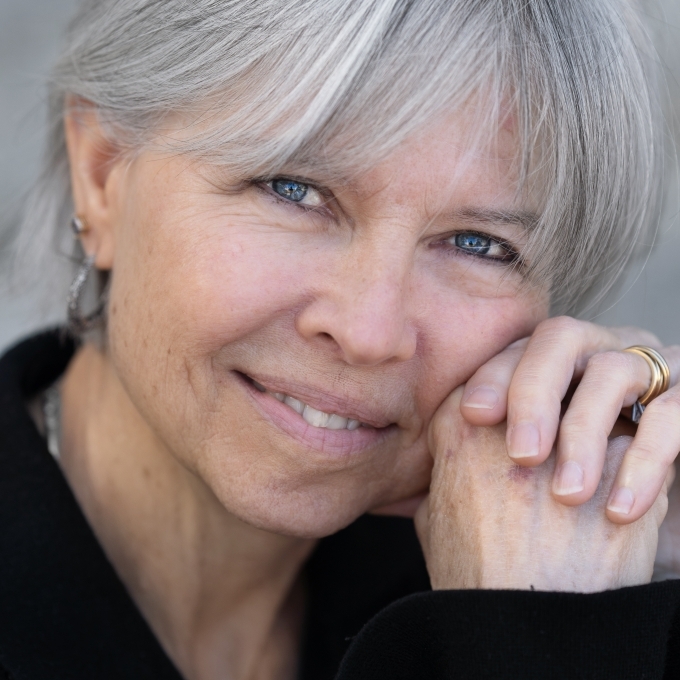 a middle aged woman with white hair wearing a black top