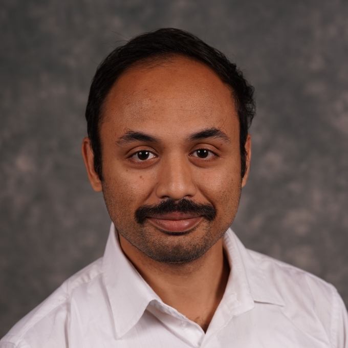 an older man wearing a white collar shirt with a mustache