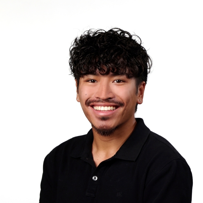 a young man wearing a black collared shirt with black hair