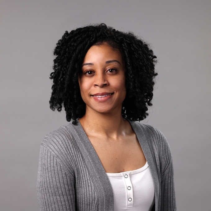 Erica Calhoun wearing a white camisole and grey cardigan