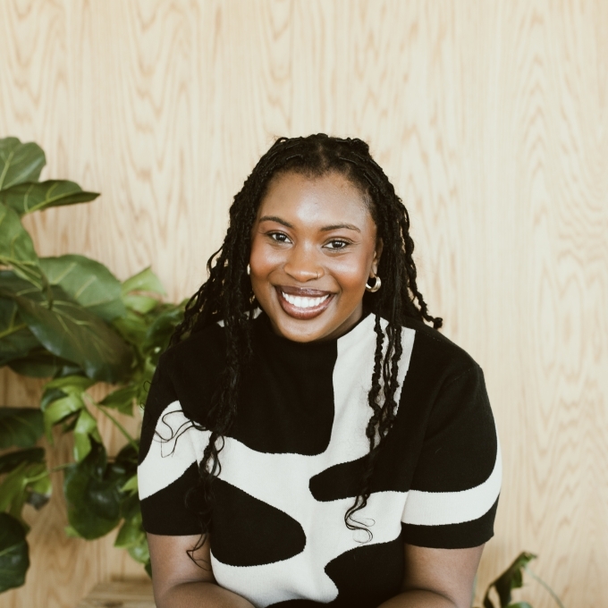 a young Black woman wearing a black and white top