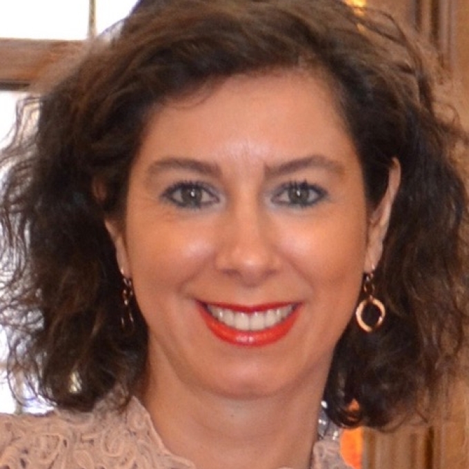 a middle aged woman with short curly brown hair 