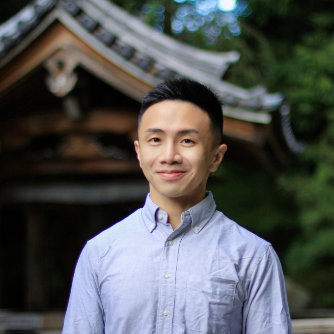 a young Asian man wearing a collared blue shirt 