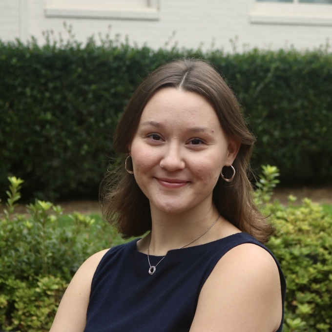 a young woman with short brown hair wearing a navy top