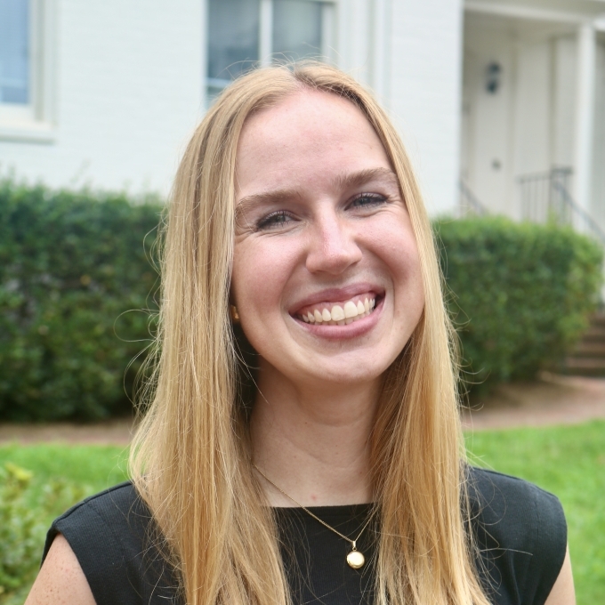 a young woman with blonde hair wearing a black top