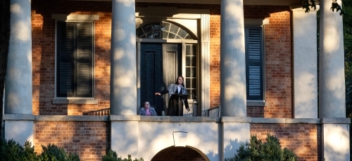 A student standing on Phi Hall balcony during the Phi Eu Debate