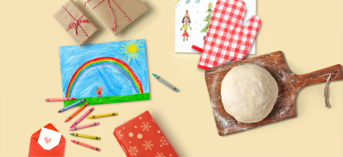 Crayon drawings, wrapped gift boxes, sour dough bread on a cutting board, and an oven mitt on a yellow background