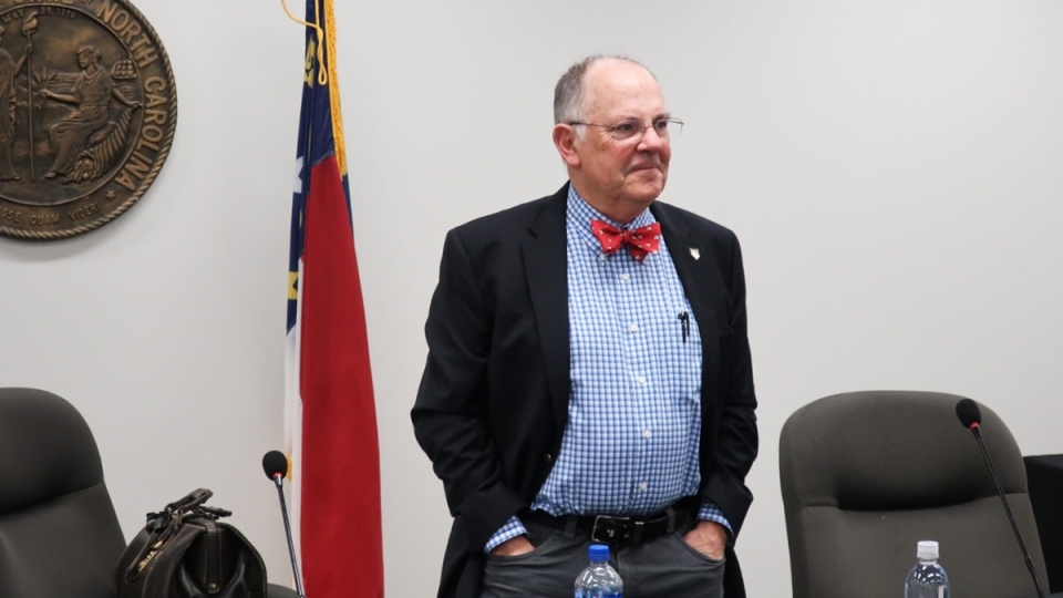 Bob Cordle stands in front of NC flag