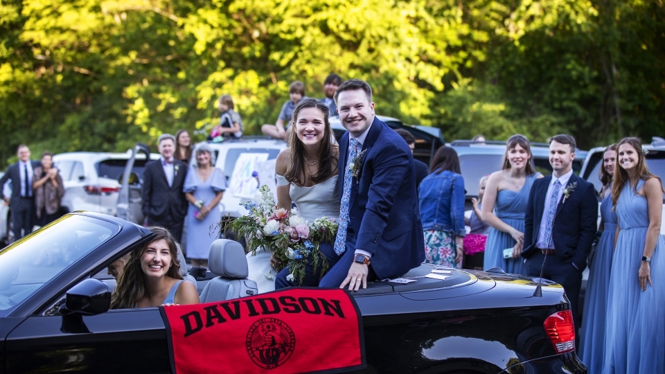 Caroline Bell '17 in car with husband and Davidson flag hanging out