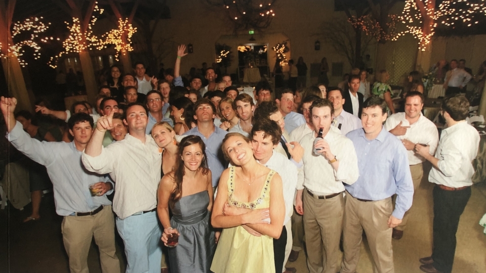 Molly and David at their wedding with friends and fireworks