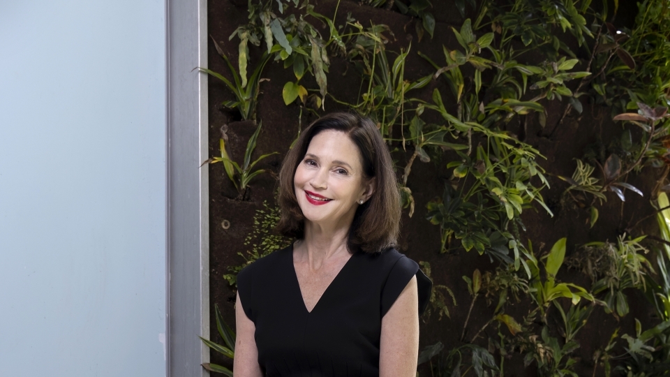 President Carol Quillen in front of plant wall