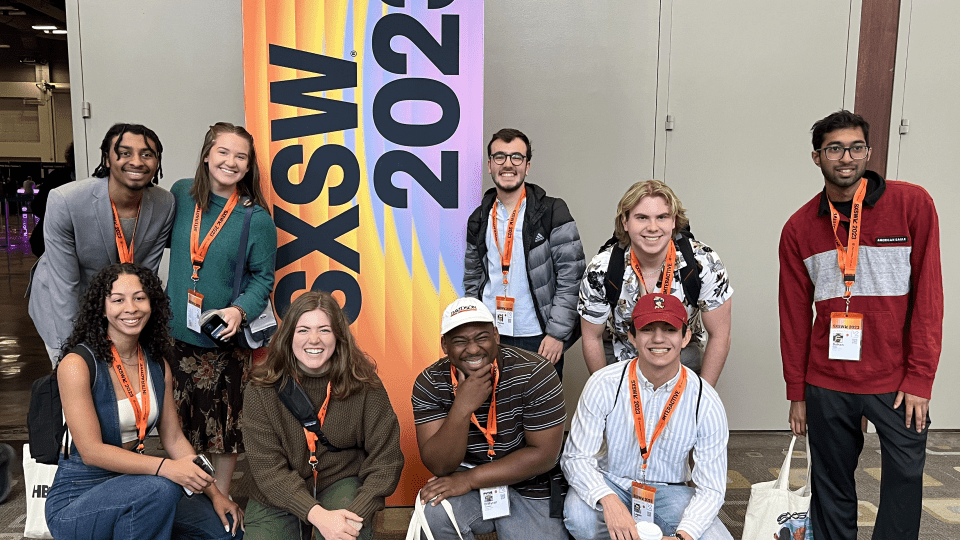 Group of students standing in front of a sign that says "SXSW"
