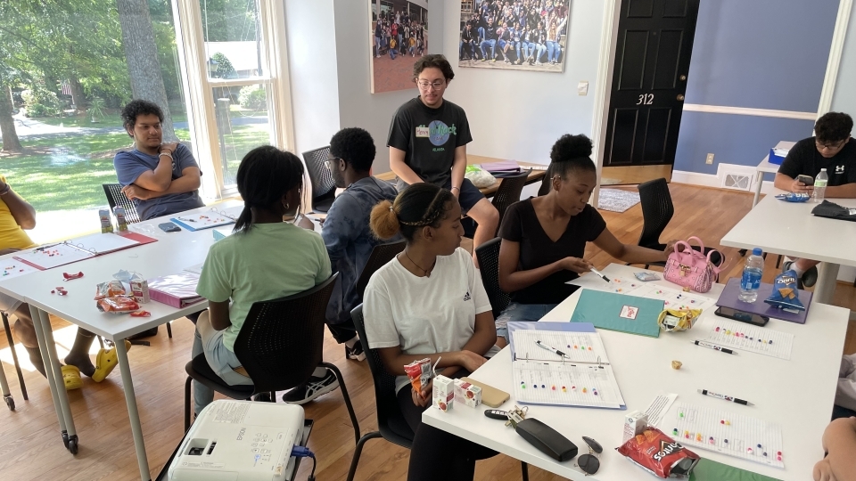a group of young people in a classroom working at tables together