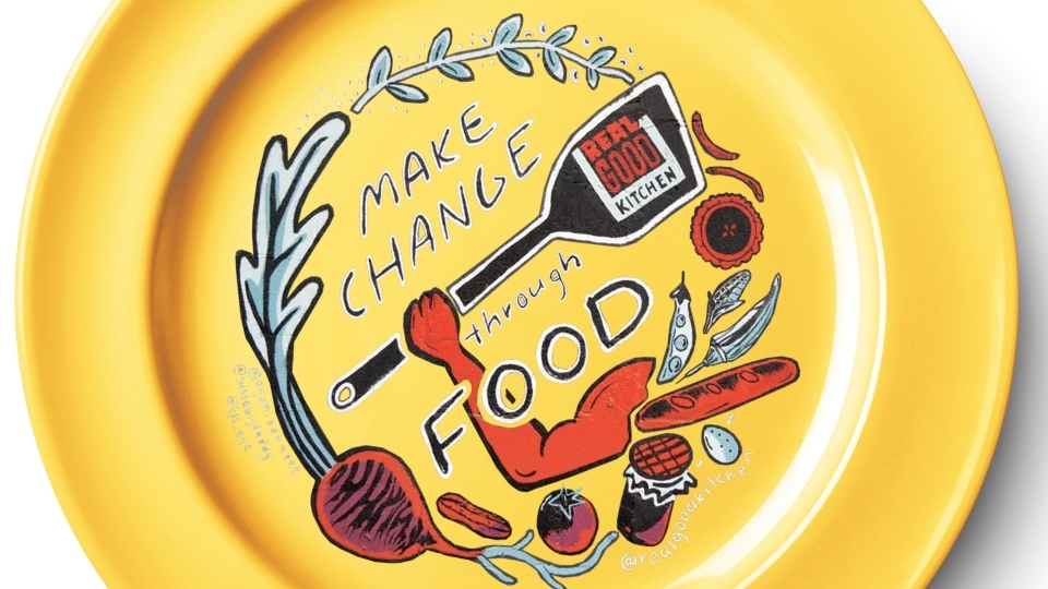 Real Good Kitchen mural superimposed on a yellow plate