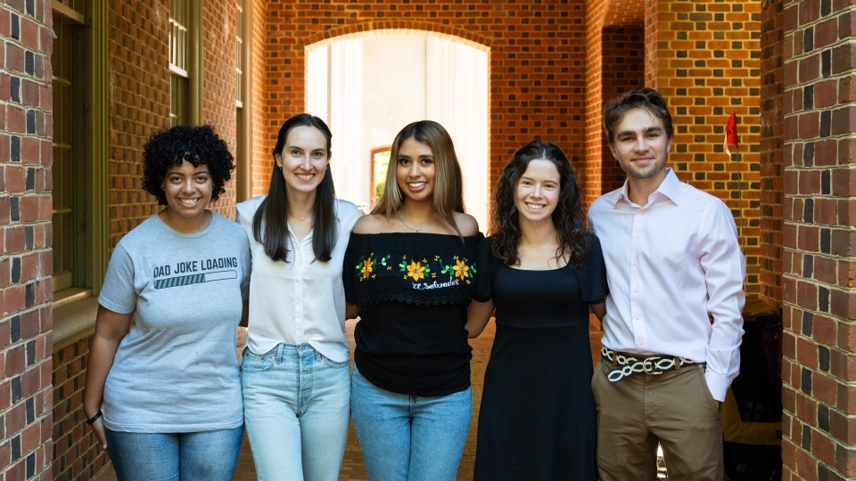 a group of young people standing together in a brick hallway