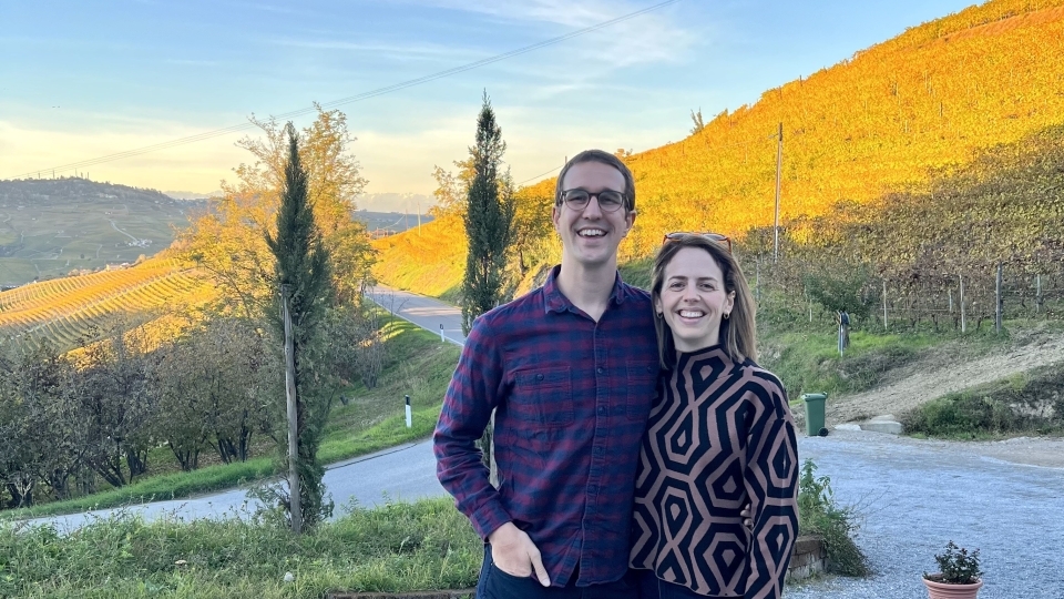 a young couple standing in front of a mountainside