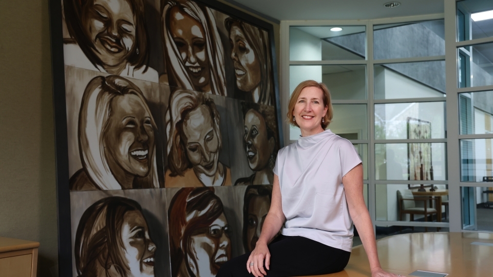 YWCA's Kirsten Sikkelee in front of painting