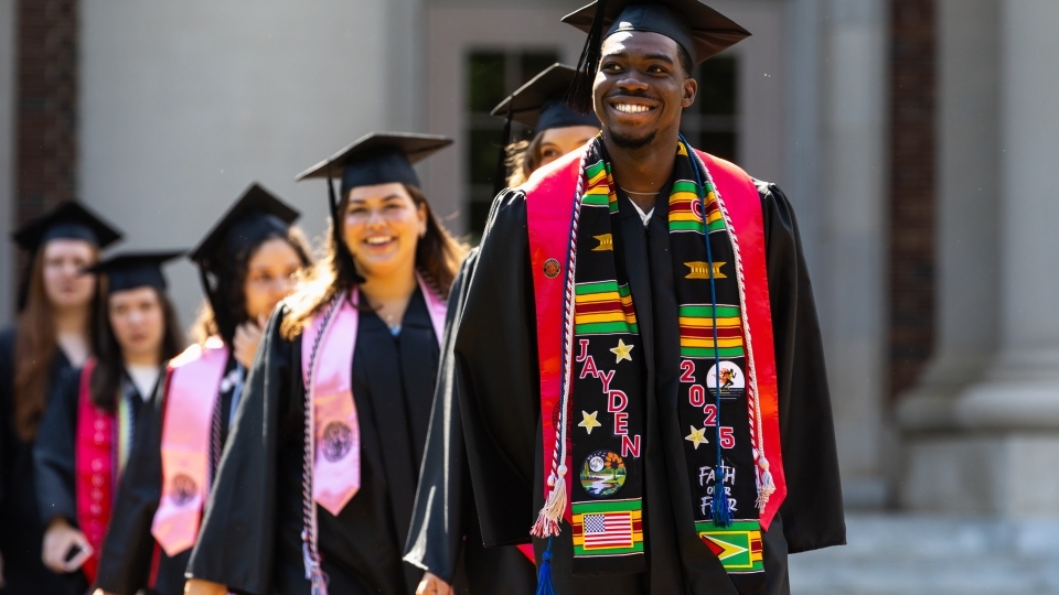 Commencement 2025 students smiling in procession 