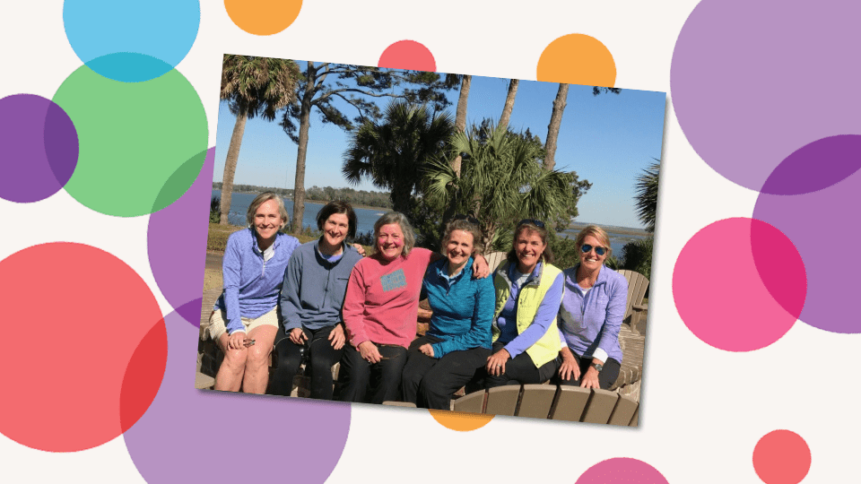 a group of women sitting together in a sunny coastal location