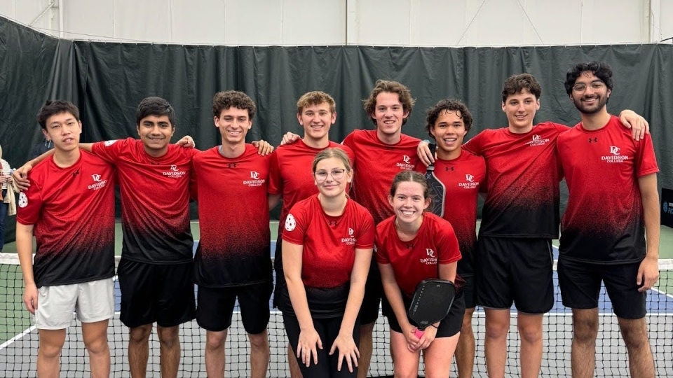 a group of pickleball players on an indoor court wearing red uniforms