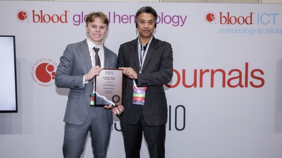 Joshua Wischmeyer, a junior biology major from Denver, Colorado, receiving award