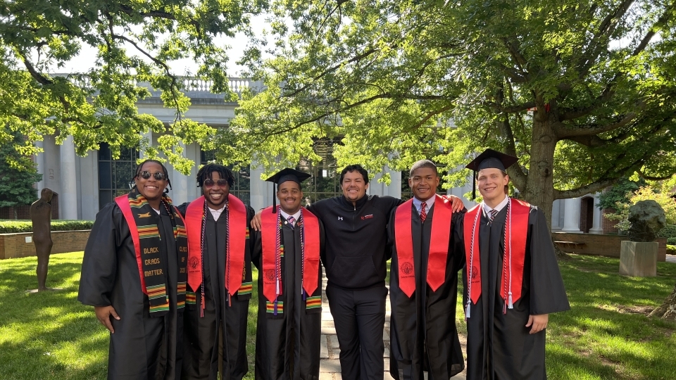 Julian Rawlins ’25 with colleagues at graduation
