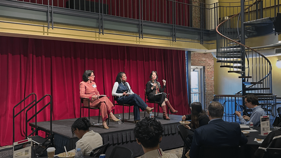 Three female panelists sit onstage in the 900 room on Davidson's campus