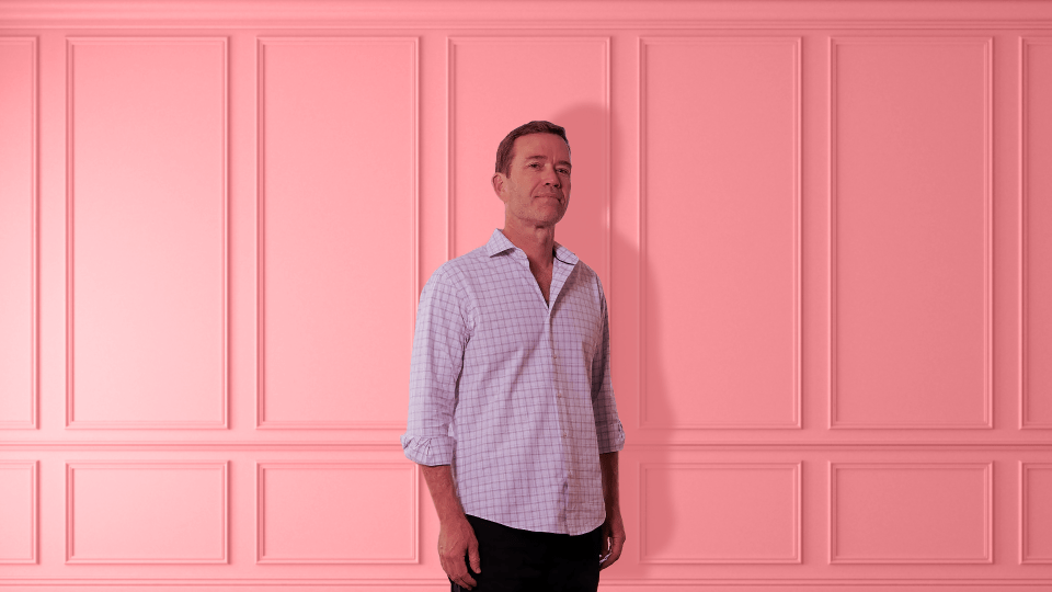 Man standing against pink wainscoting